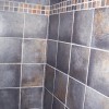 Bathroom tile walls with decorative 1” band to match shower floor in home on Bradley Boulevard in Bethesda, MD.